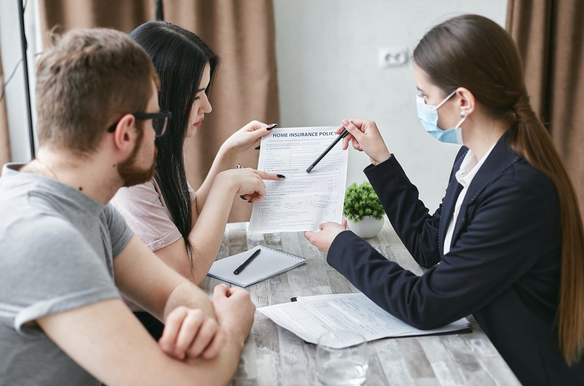Insurance agent 4 a woman explaining a document to a couple