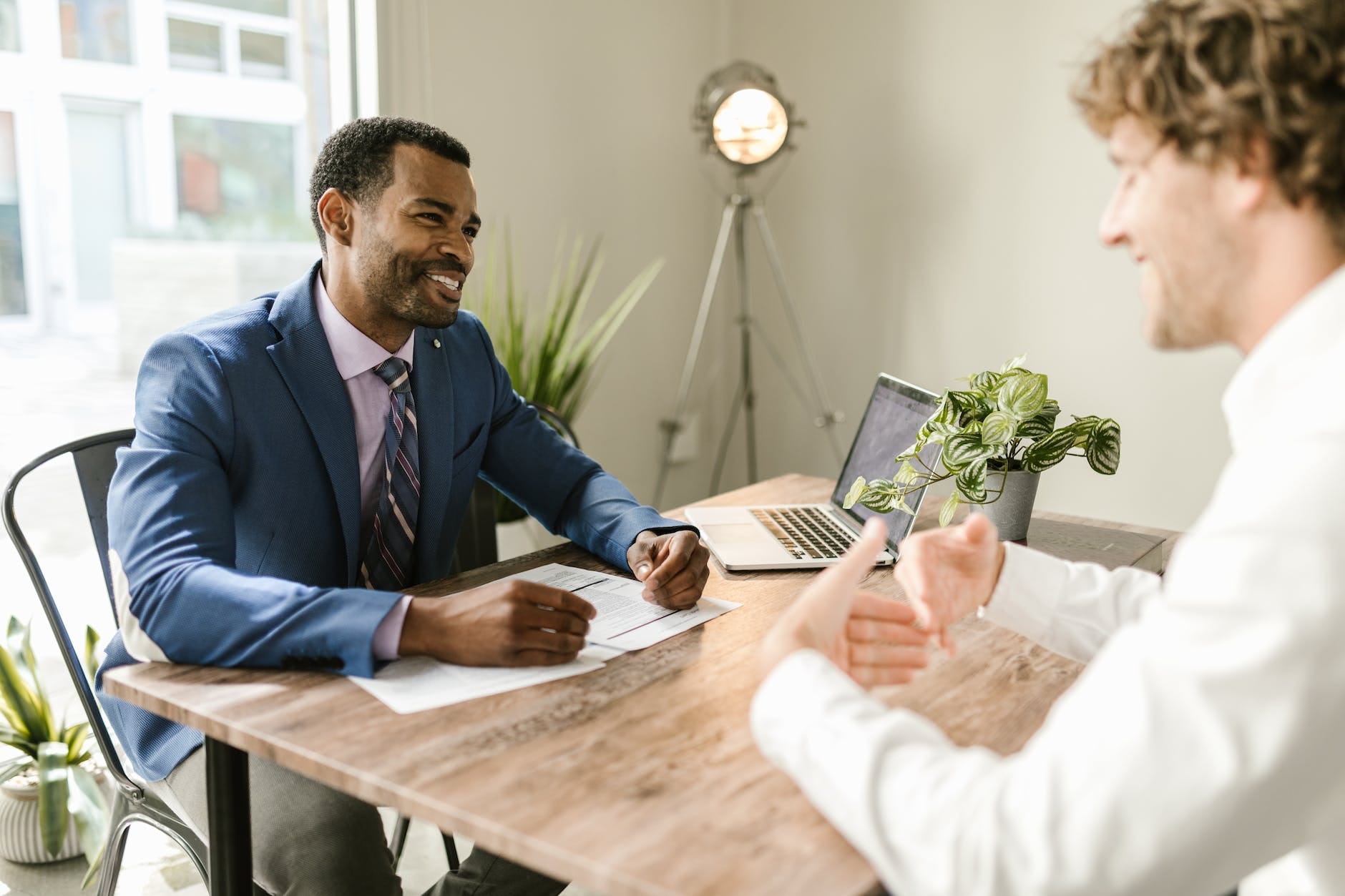 Insurance agent 3 men sitting at table smiling