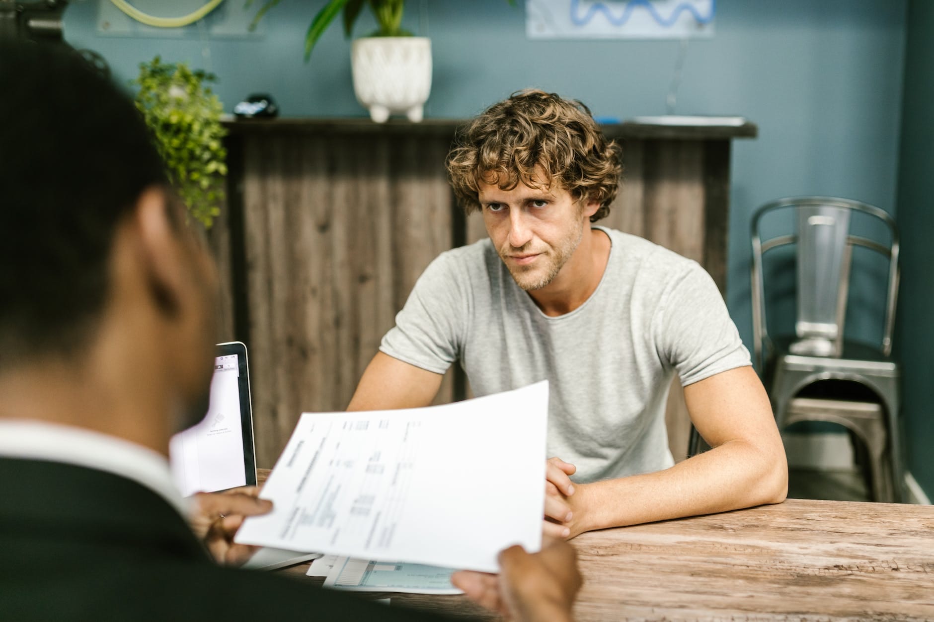 Insurance agent 8 man in gray shirt sitting by the table